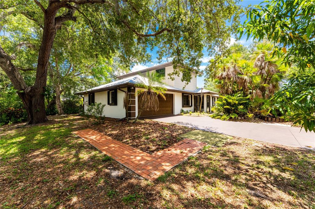 A two-story house with a brown garage, white siding, and a brick walkway in front — 4880 WECOMA AVENUE, NORTH PORT, FL