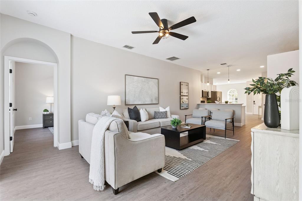 A living room features light gray walls, wood-look flooring, a ceiling fan, and neutral furniture — 1209 CATHCART CIRCLE, SANFORD, FL