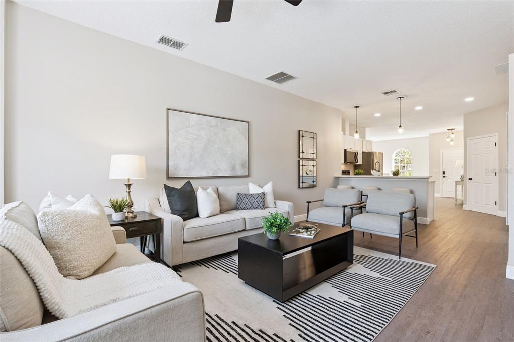 A living room features a neutral sofa, two armchairs, a coffee table, and wood flooring — 1209 CATHCART CIRCLE, SANFORD, FL