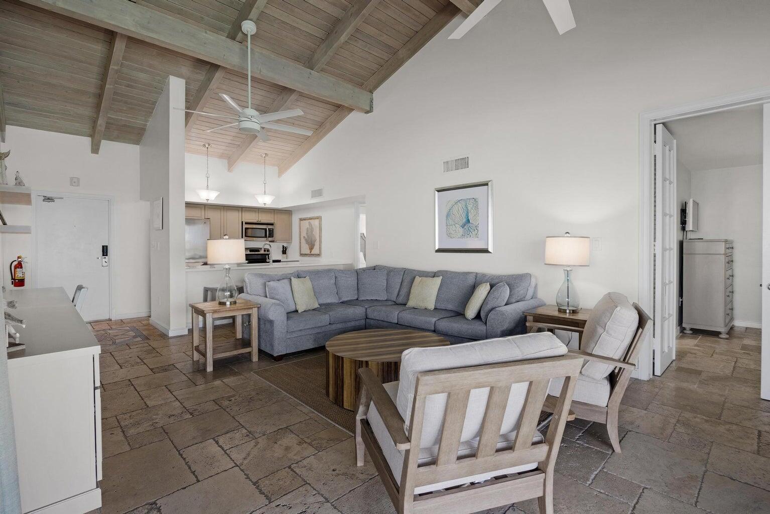 A living room with a vaulted wood ceiling, sectional sofa, and light-colored tile flooring — 4402 Marina Villa Drive, Marathon FL 33050, MARATHON, FL