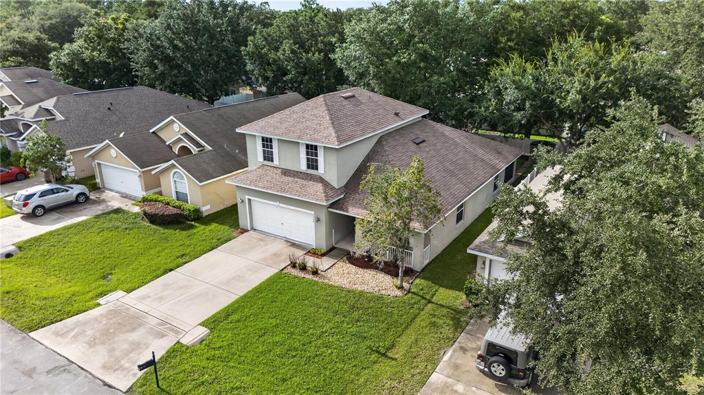 An aerial view shows a two-story suburban house with a driveway and a green lawn — 2020 BRIARCLIFF CIRCLE, MOUNT DORA, FL