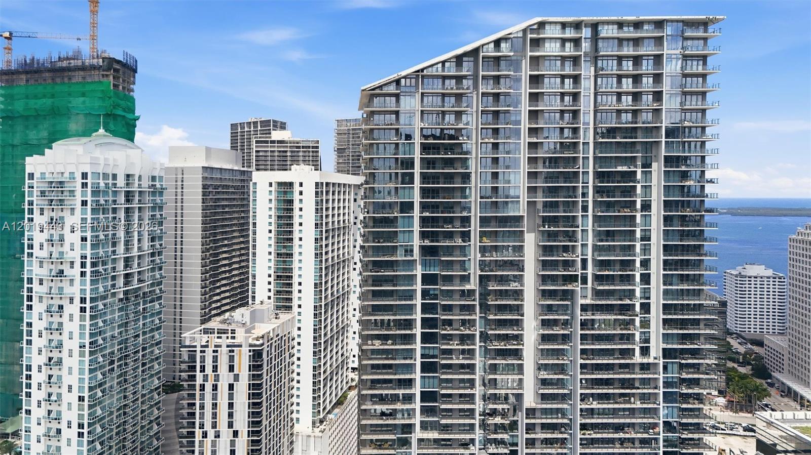 An exterior view of several modern high-rise apartment buildings under a blue sky — 68 SE 6th St # 2702, Miami FL 33131, MIAMI, FL