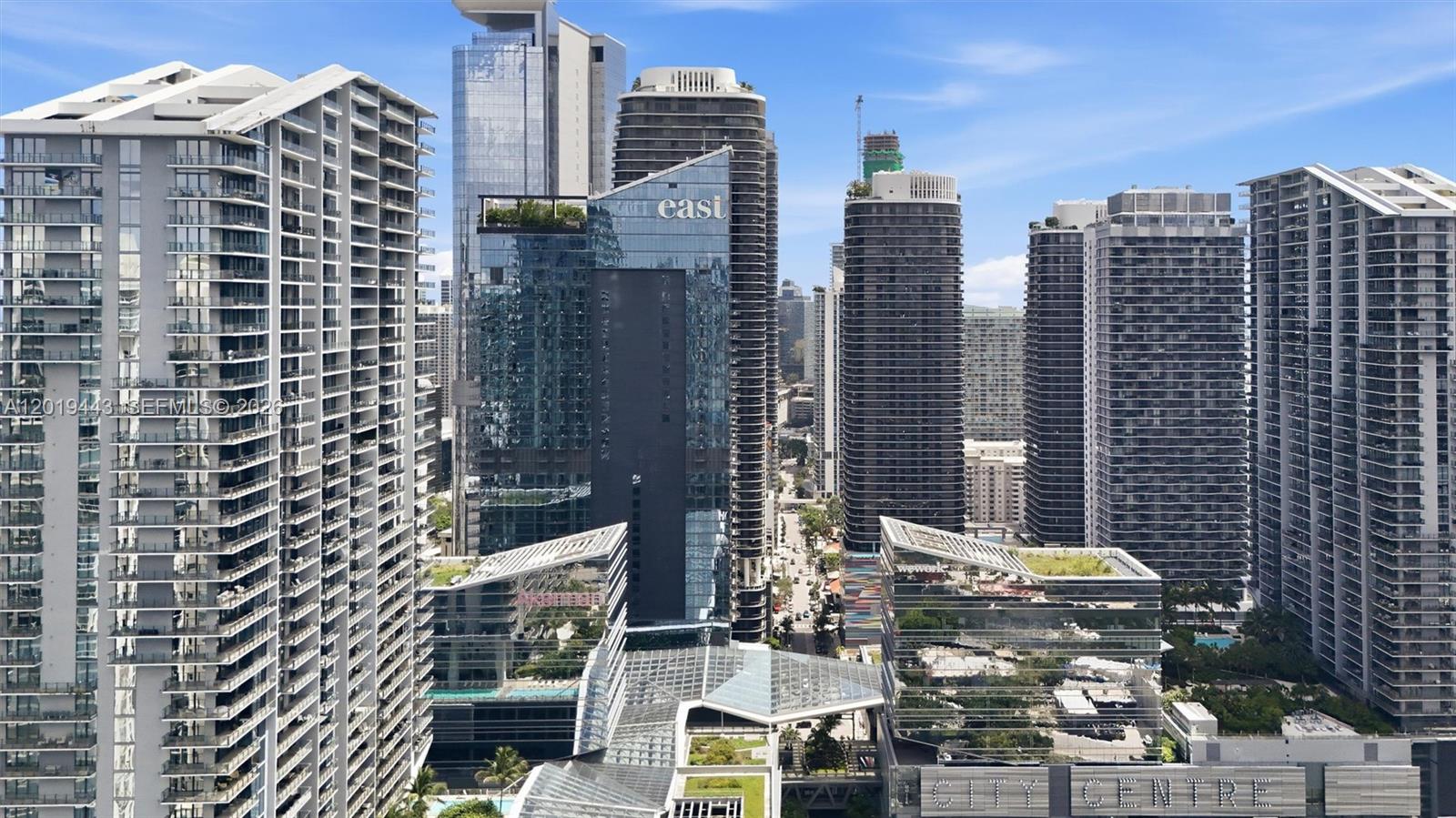 An elevated view of a dense urban skyline featuring multiple modern high-rise residential and commercial buildings — 68 SE 6th St # 2702, Miami FL 33131, MIAMI, FL