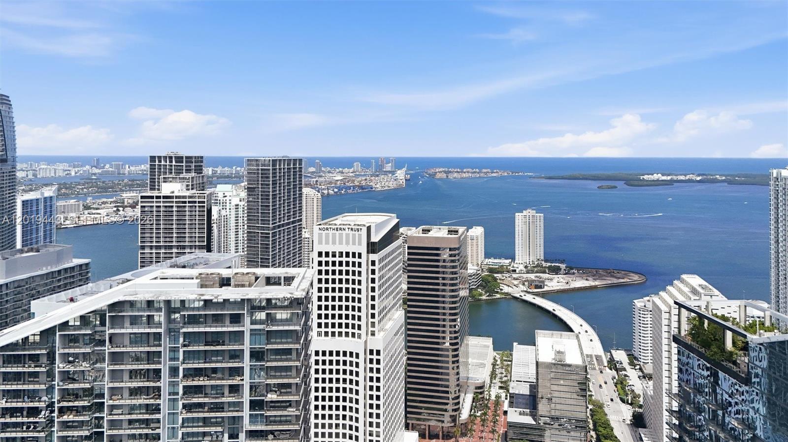 An elevated view of a dense city skyline overlooking a large bay and ocean — 68 SE 6th St # 2702, Miami FL 33131, MIAMI, FL