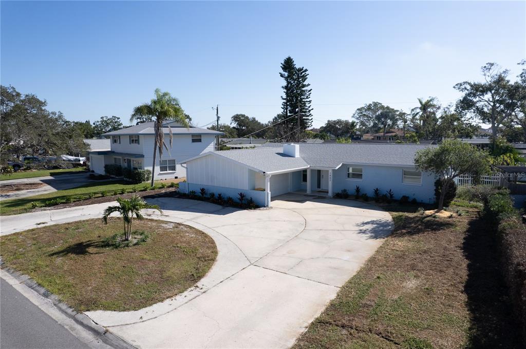 An aerial view shows a light blue single-story house with a circular concrete driveway — 1897 DOLPHIN BOULEVARD S, ST PETERSBURG, FL
