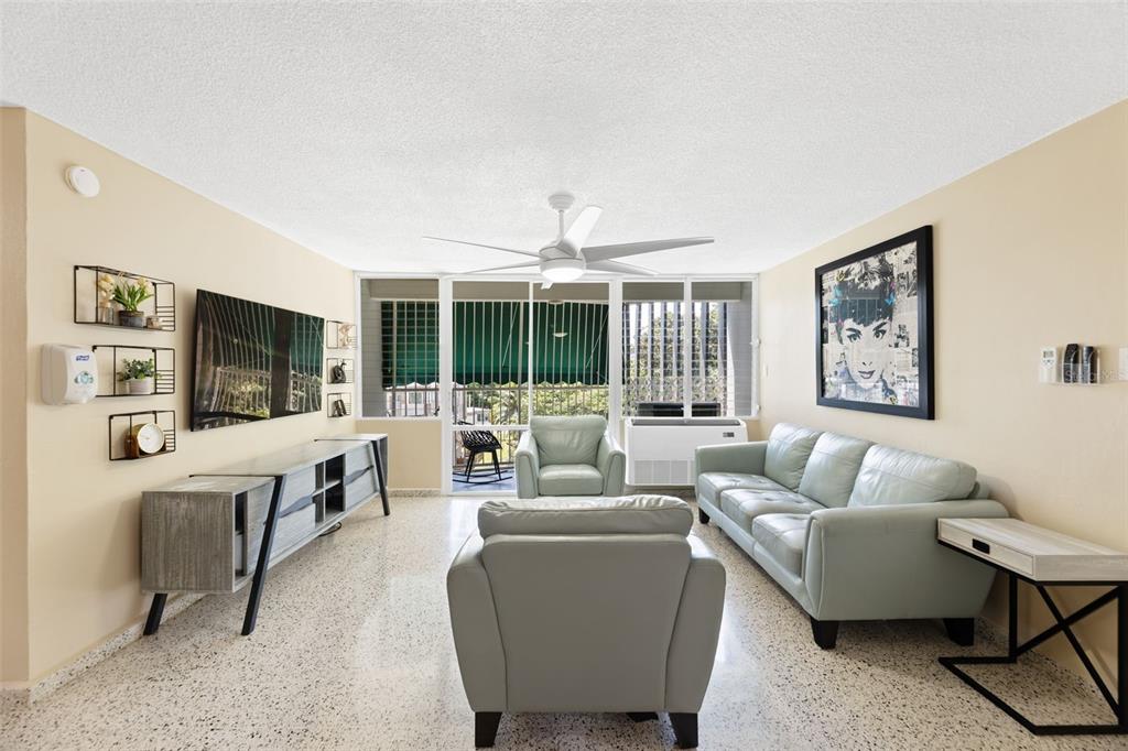 A living room features light-colored leather furniture, a television, and a balcony with green awnings — 472 CALLE DE DIEGO UNIT 602 B, SAN JUAN, PR