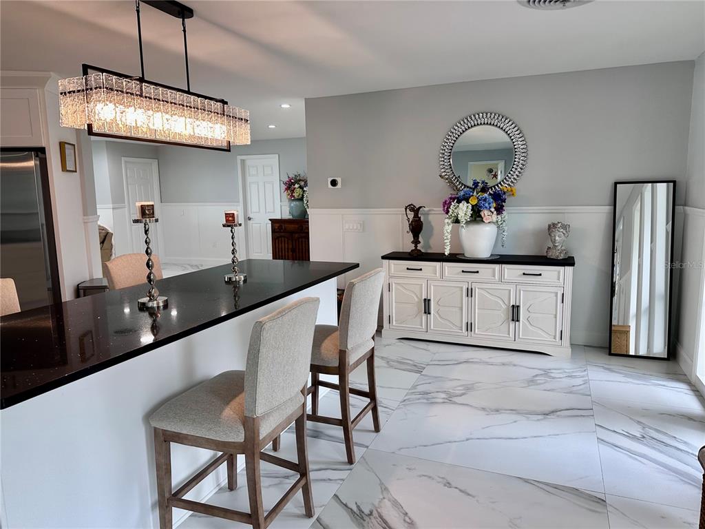 A kitchen with a black countertop island, bar stools, and a white sideboard against a wall — 12000 W BAYSHORE DRIVE, CRYSTAL RIVER, FL