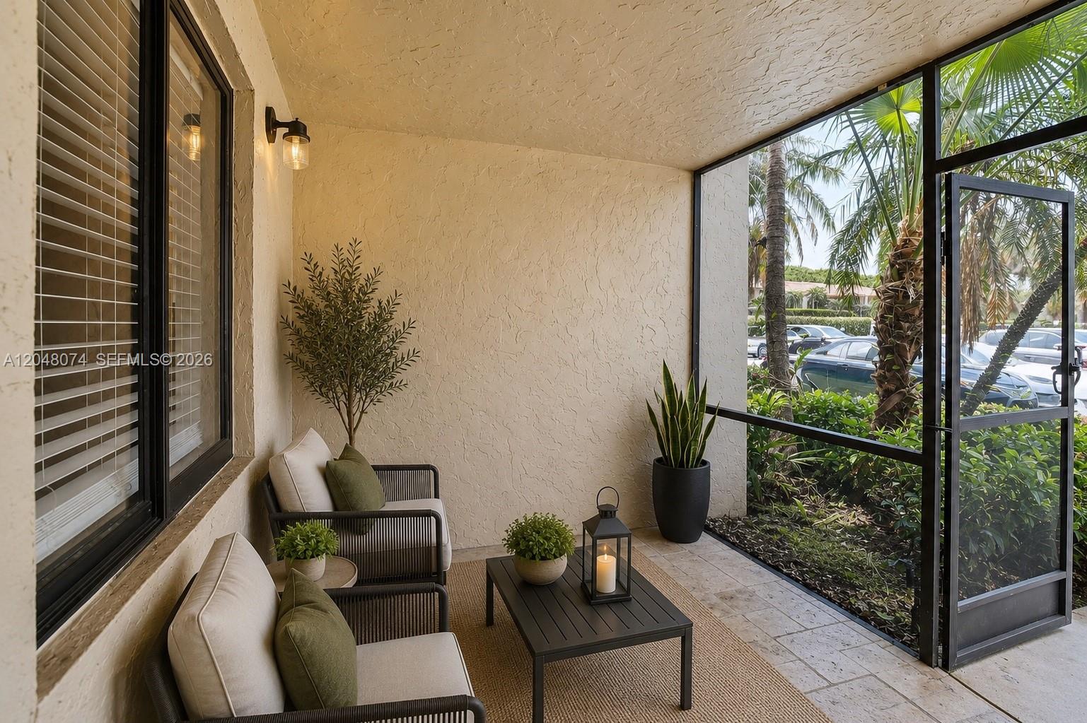 A screened-in patio features two chairs, a coffee table, and a view of palm trees — 359 Lakeview Dr # 102, Weston FL 33326, WESTON, FL