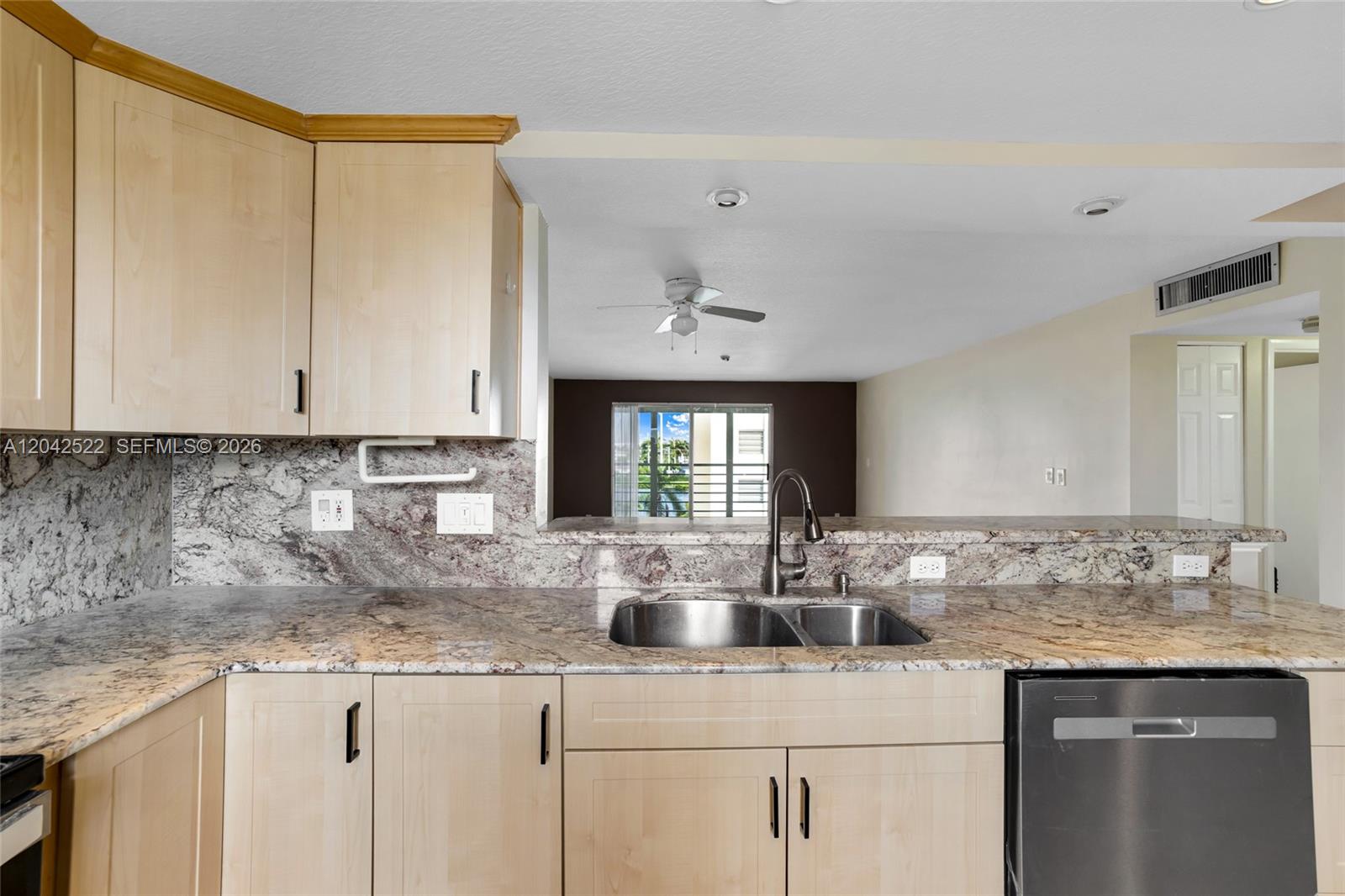 A kitchen features light wood cabinets, granite countertops, a stainless steel sink, and a dishwasher — 321 SE 3rd St # 408, Dania Beach FL 33004, DANIA BEACH, FL