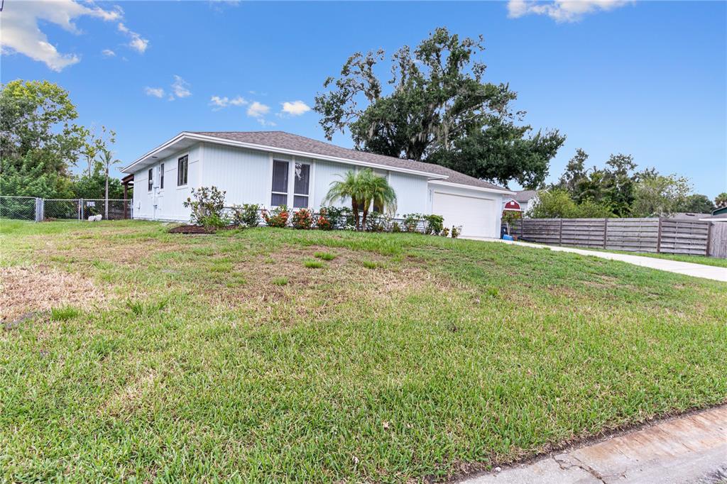 A single-story house with light blue siding, a two-car garage, and a grassy front yard — 5011 LEON DRIVE, PALMETTO, FL