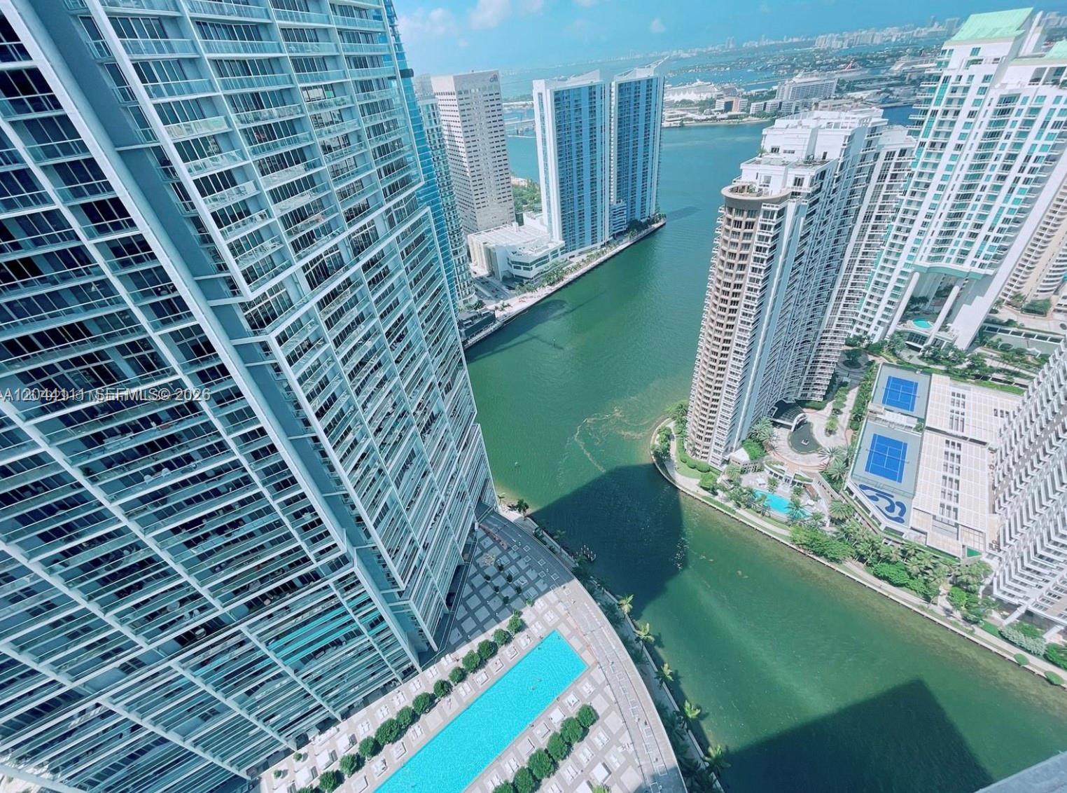 High-angle view of waterfront high-rise apartment buildings, a swimming pool, and a tennis court — 495 Brickell Ave # 4804, Miami FL 33131, MIAMI, FL