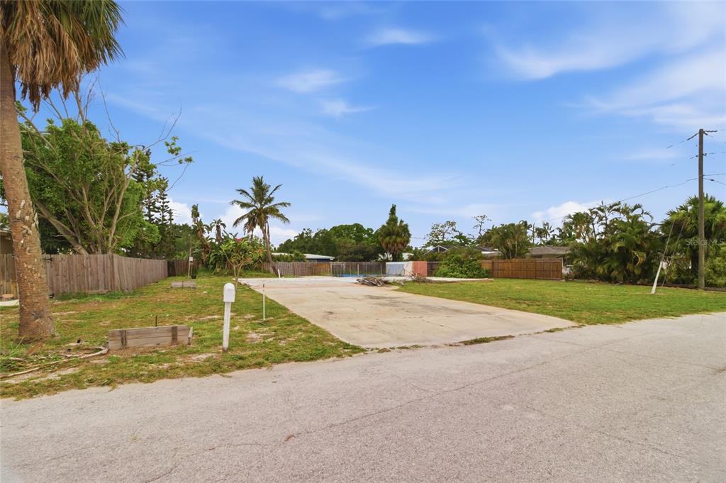 A vacant residential lot features a concrete slab foundation, a mailbox, and surrounding wooden fencing — 1308 62ND STREET NW, BRADENTON, FL