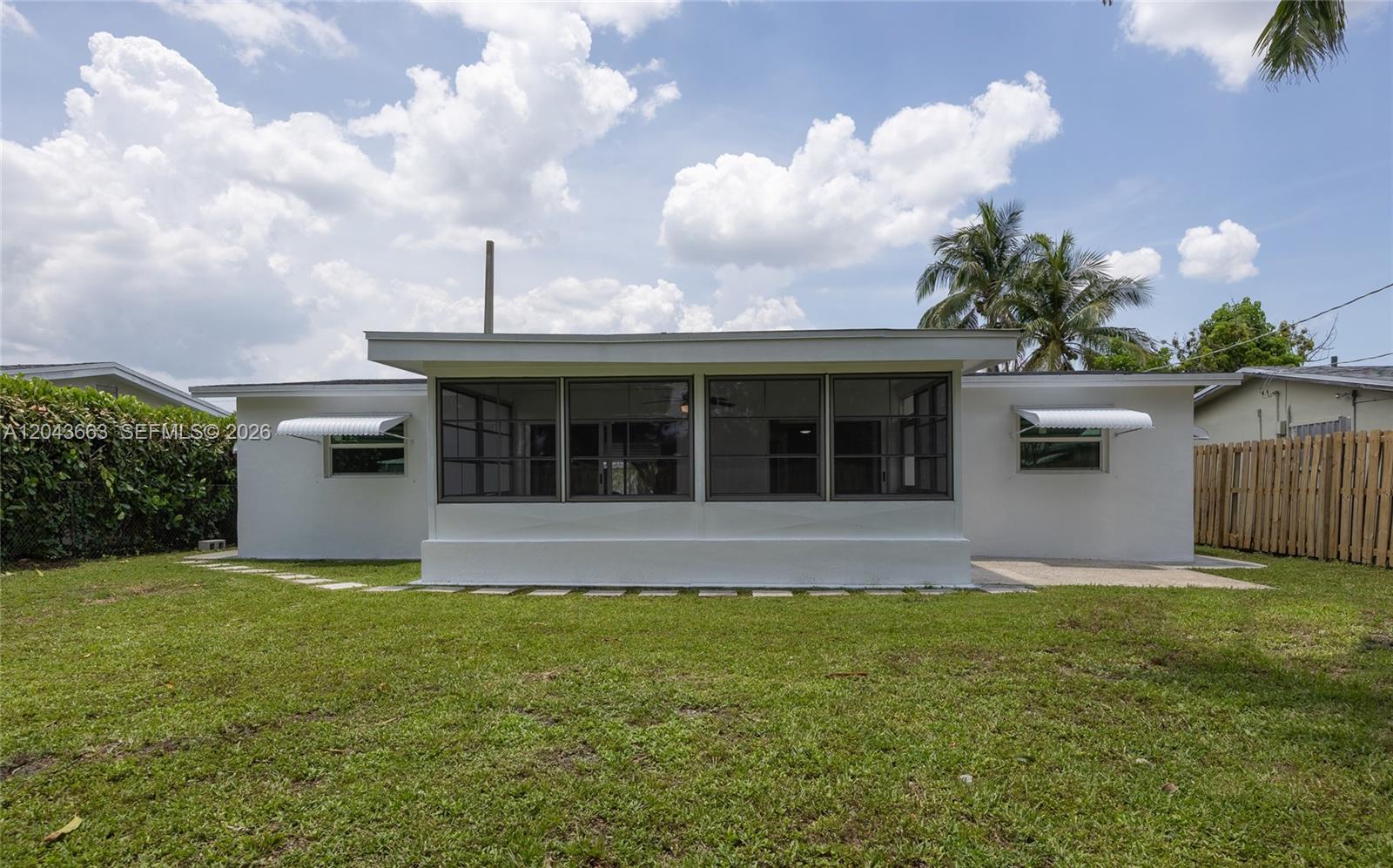 The exterior view shows a white house with a screened-in porch and a grassy yard — 8571 NW 27th Pl, Sunrise FL 33322, SUNRISE, FL