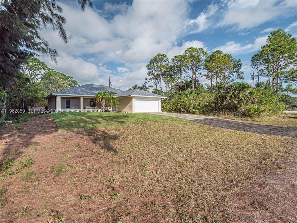 A single-story house with a white garage door and a covered front porch — 8265 97th Ave, Vero Beach FL 32967, VERO BEACH, FL