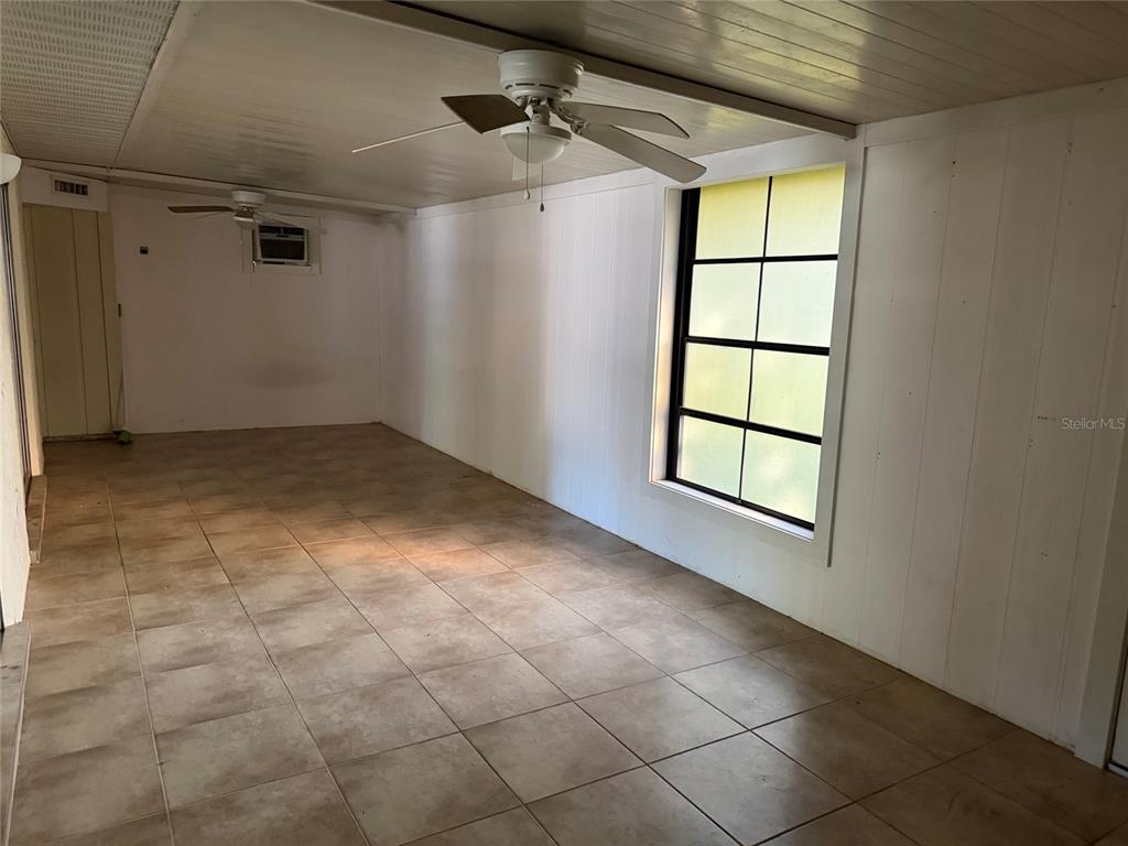 An enclosed porch features white paneled walls, a tiled floor, and two ceiling fans — 4805 LANDOVER CIRCLE, ORLANDO, FL