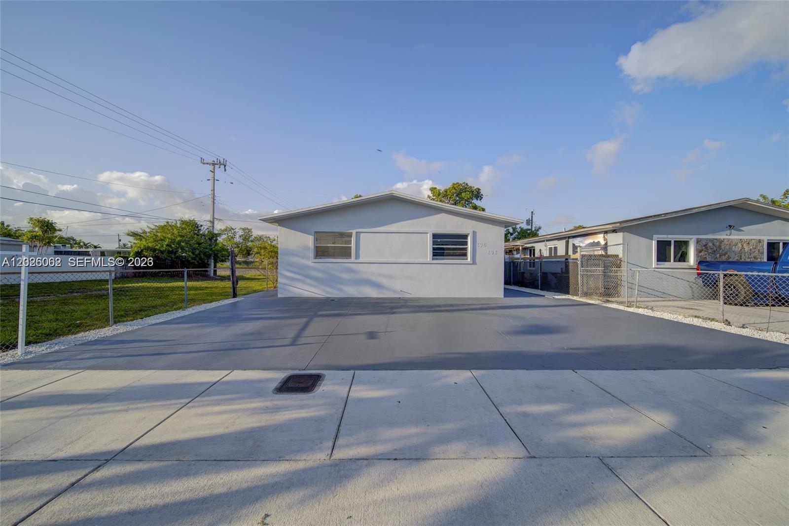 A single-story house with a white exterior and a large gray concrete driveway — 896 E 22nd St # 898, Hialeah FL 33013, HIALEAH, FL