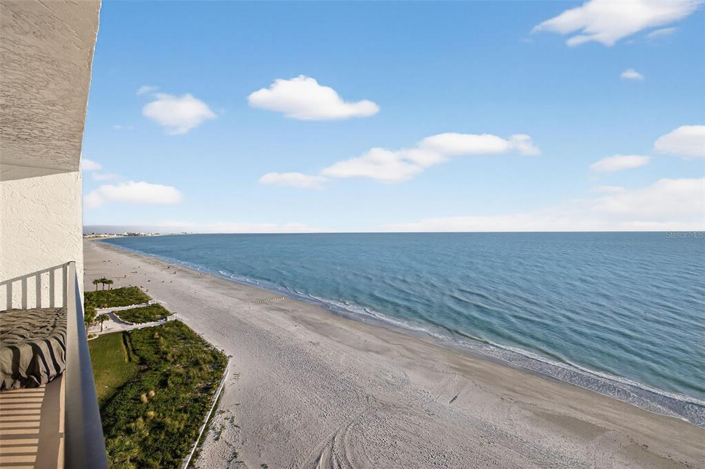 A high-angle view from a balcony overlooking a sandy beach and the ocean — 15316 GULF BOULEVARD UNIT 903, MADEIRA BEACH, FL