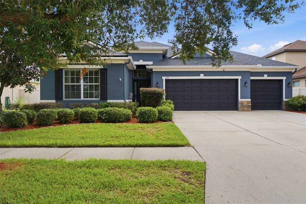A screened-in patio features a rectangular swimming pool, light-colored stone pavers, and a white fence — 11105 WEMBLEY LANDING DRIVE, LITHIA, FL