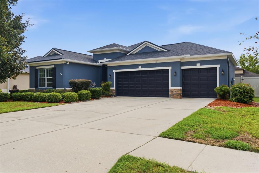 An entryway with tile flooring, a white front door, and a black storage unit — 11105 WEMBLEY LANDING DRIVE, LITHIA, FL