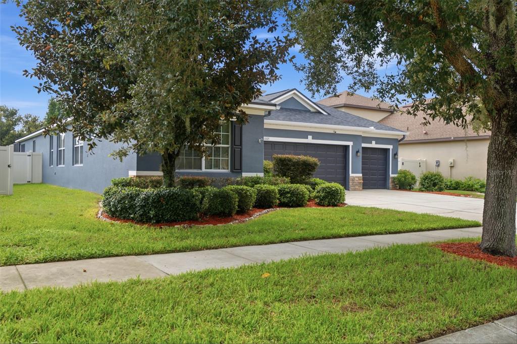 A foyer with tile floors leads into a hardwood-floored room containing a home gym setup — 11105 WEMBLEY LANDING DRIVE, LITHIA, FL
