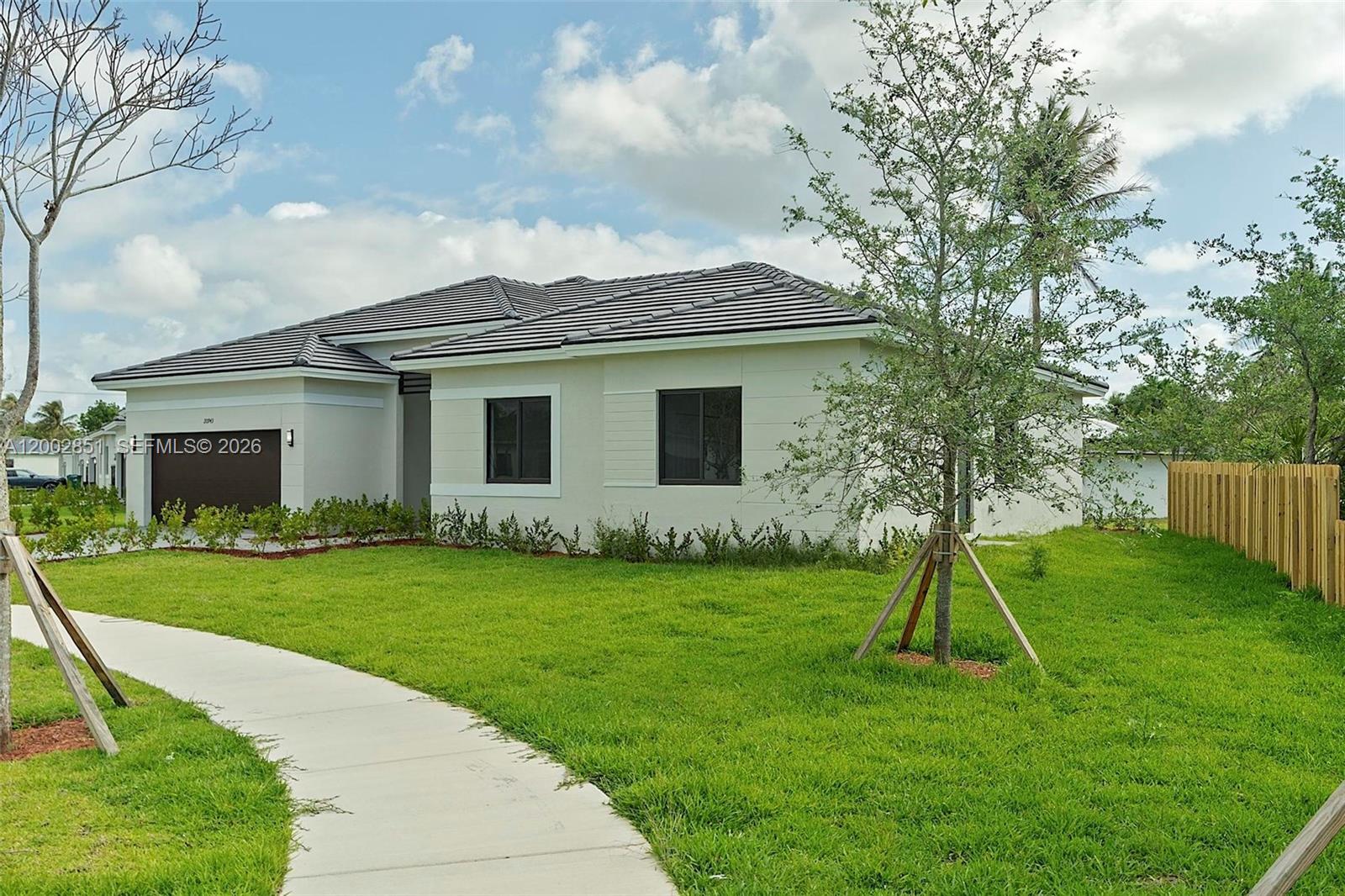 A modern single-story house with a dark roof, light-colored walls, and a concrete walkway — 20943 SW 96th Ct, Cutler Bay FL 33189, CUTLER BAY, FL