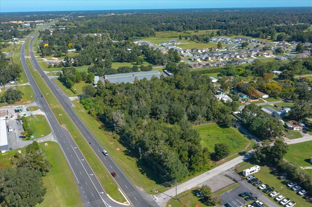 An aerial view shows a wooded lot adjacent to a highway and residential neighborhood — N US HWY 441, OCALA, FL