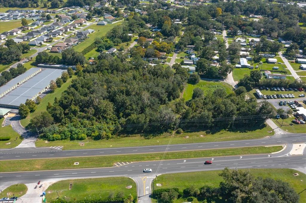 An aerial view shows a wooded lot situated between a highway and a residential neighborhood — N US HWY 441, OCALA, FL