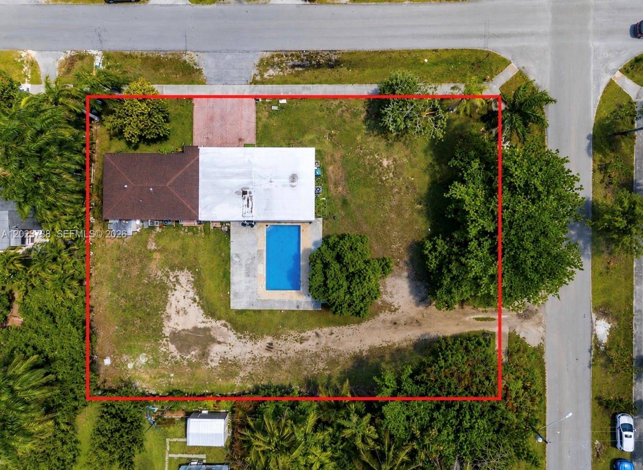 An aerial view shows a house with a swimming pool on a large, grassy lot — 329 NW 13th St, Homestead FL 33030, HOMESTEAD, FL