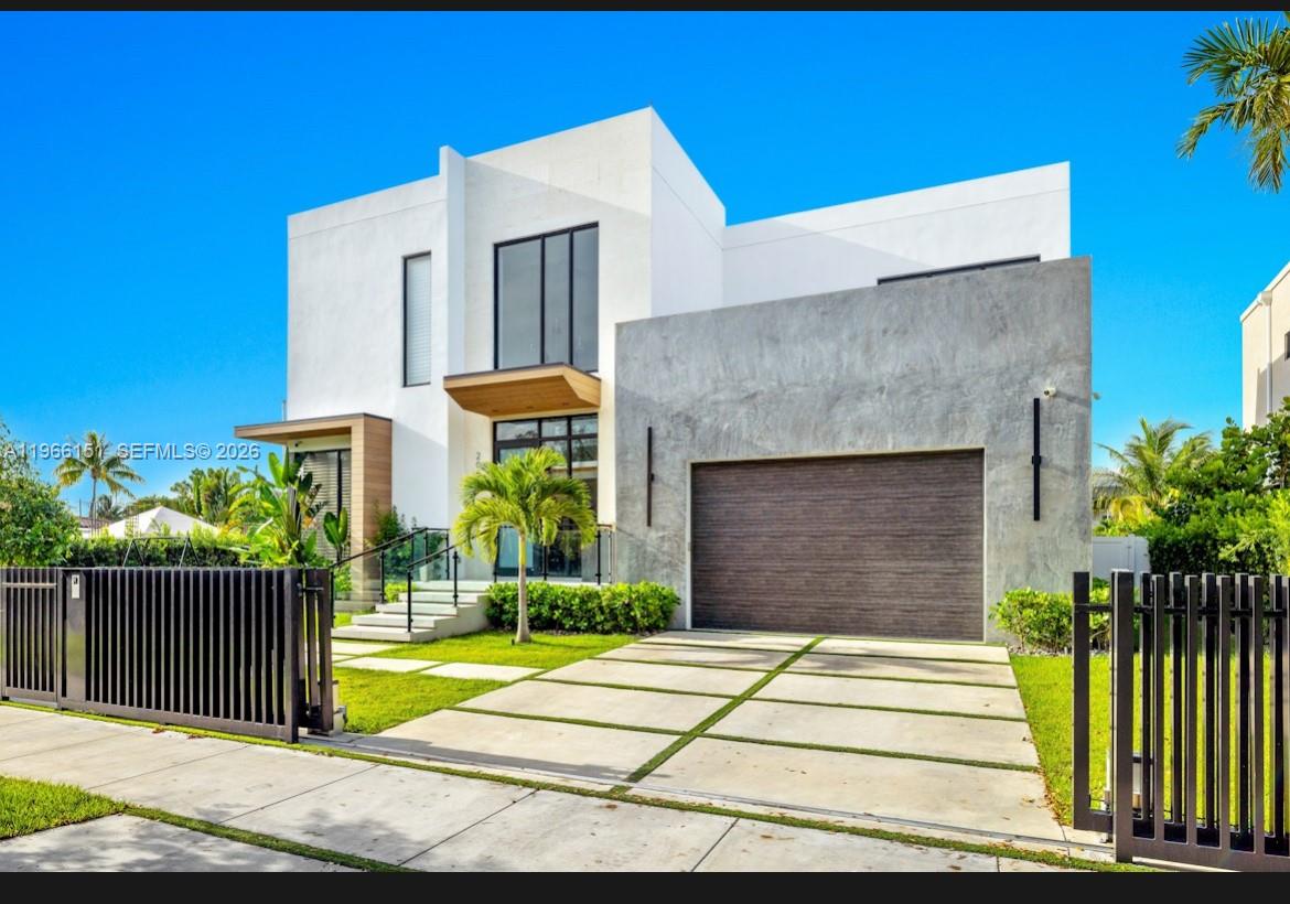 A modern two-story house features a concrete garage, white exterior walls, and a paved driveway — 2050 S Hibiscus Dr, North Miami FL 33181, NORTH MIAMI, FL