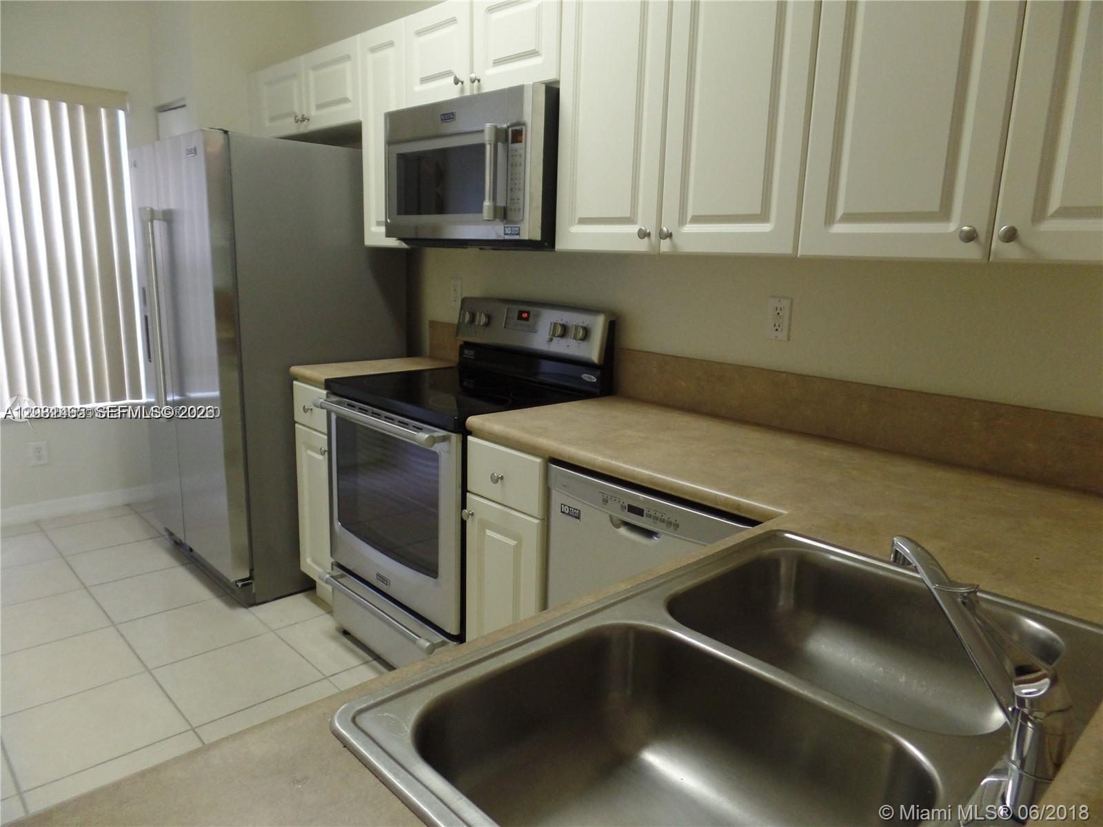 A kitchen features white cabinets, stainless steel appliances, a double sink, and beige countertops — 14055 SW 49th St # 6, Miramar FL 33027, MIRAMAR, FL