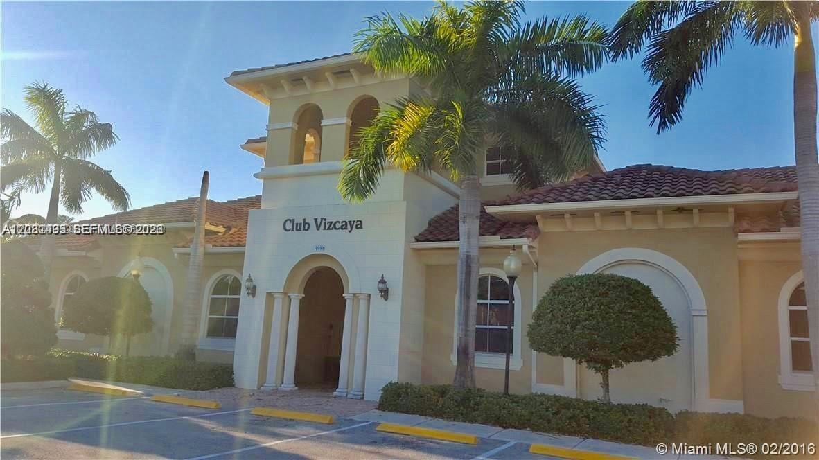 The exterior of the Club Vizcaya clubhouse features a beige stucco facade and palm trees — 14055 SW 49th St # 6, Miramar FL 33027, MIRAMAR, FL