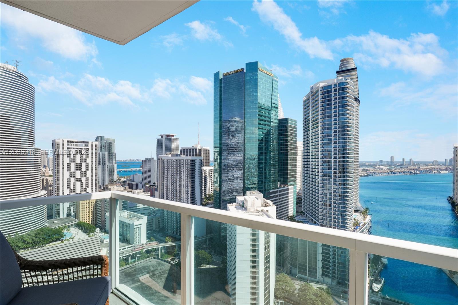 A balcony view overlooking the Miami skyline, high-rise buildings, and the blue bay water — 31 SE 5th St # 3812, Miami FL 33131, MIAMI, FL