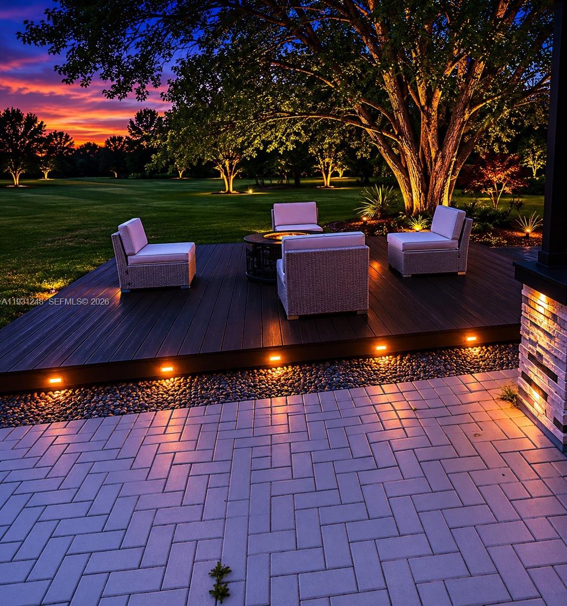 An outdoor deck with seating and a fire pit overlooks a lawn at sunset — 4905 Banyan Lane, Tamarac FL 33319, TAMARAC, FL