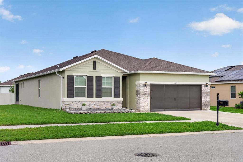 A single-story house with a tan exterior, stone accents, and a two-car garage — 8872 SW 63RD AVENUE, OCALA, FL