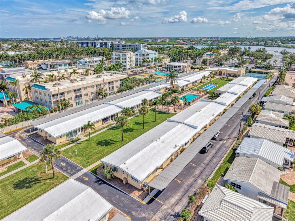 An aerial view shows a residential complex with long buildings, swimming pools, and parking areas — 6006 MIDNIGHT PASS ROAD UNIT 60, SARASOTA, FL
