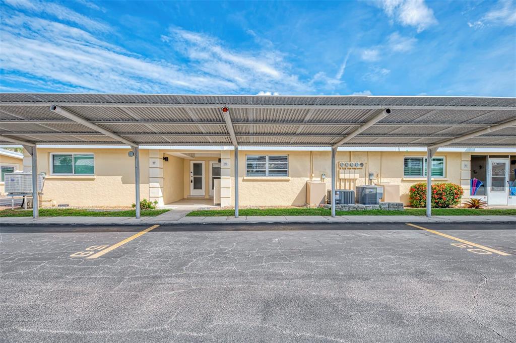 A single-story apartment building exterior with a metal carport covering the parking spaces — 6006 MIDNIGHT PASS ROAD UNIT 60, SARASOTA, FL
