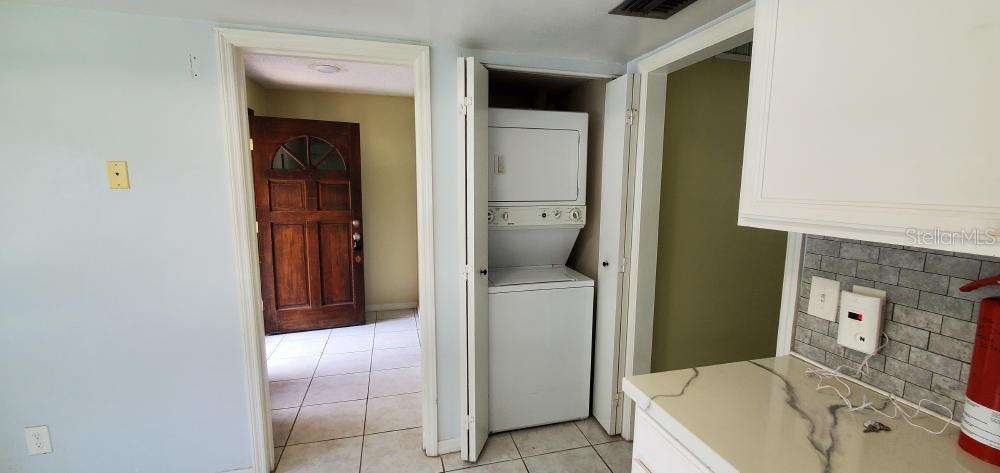A stacked washer and dryer unit sits in a closet between two doorways — 406 OAK HAVEN DRIVE UNIT 406, ALTAMONTE SPRINGS, FL