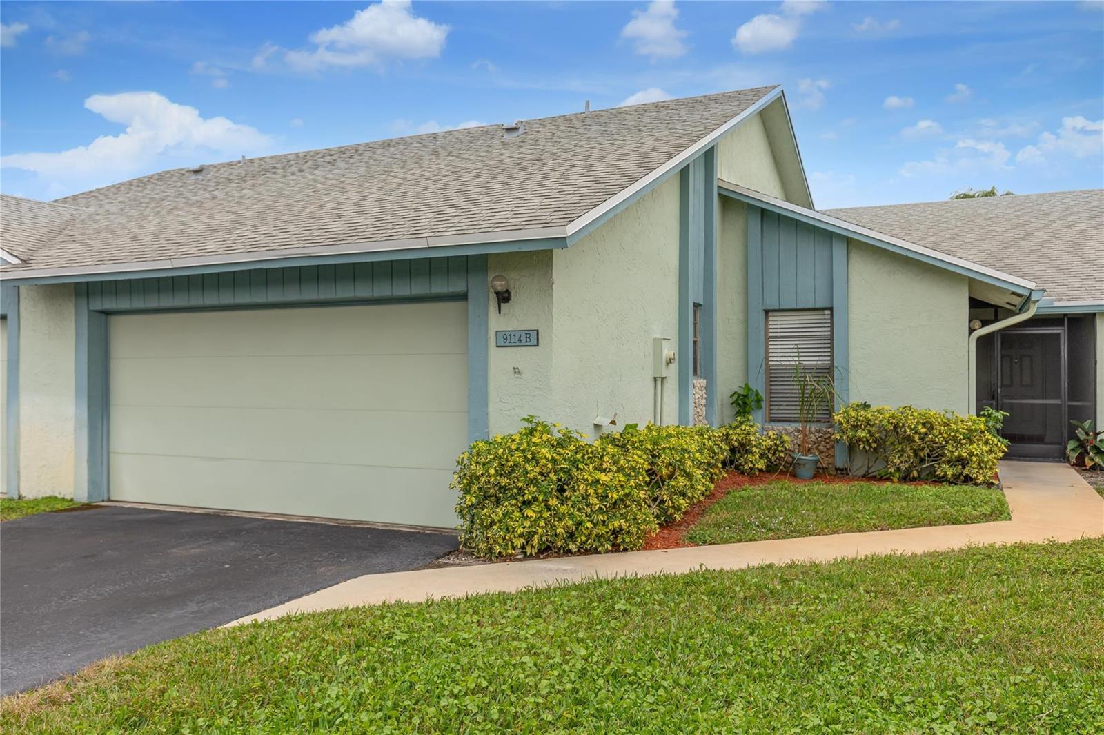 A light green single-story home features a garage, a small window, and a front walkway — 9114 SW 20th Street # B, Boca Raton FL 33428, BOCA RATON, FL