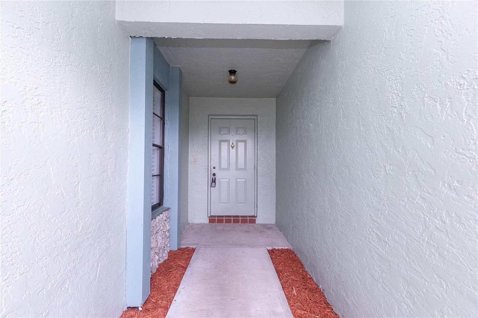 A concrete walkway leads to a white front door in a covered entryway — 9114 SW 20th Street # B, Boca Raton FL 33428, BOCA RATON, FL