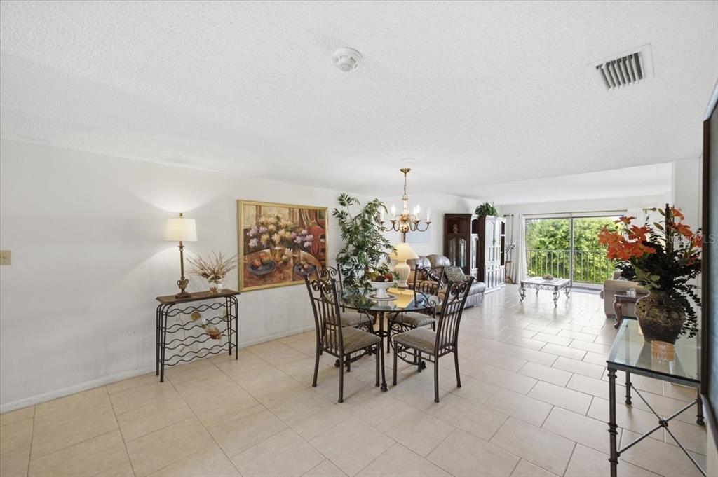 A dining area with tile floors, a glass table, and a mirrored wall — 7050 SUNSET DRIVE S UNIT 216, SOUTH PASADENA, FL