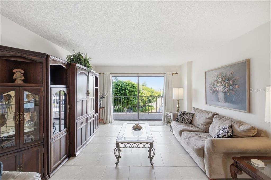 A dining area with a glass table and chairs sits in an open-concept living space — 7050 SUNSET DRIVE S UNIT 216, SOUTH PASADENA, FL