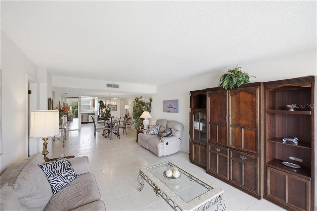 A dining area with a glass table, metal chairs, tile floors, and a chandelier — 7050 SUNSET DRIVE S UNIT 216, SOUTH PASADENA, FL