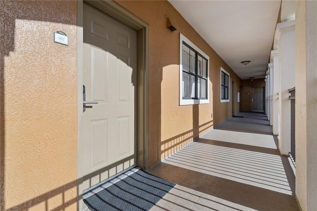 An exterior hallway with a beige door numbered 602 and a concrete walkway — 12538 FLORIDAYS RESORT DRIVE UNIT 602C, ORLANDO, FL