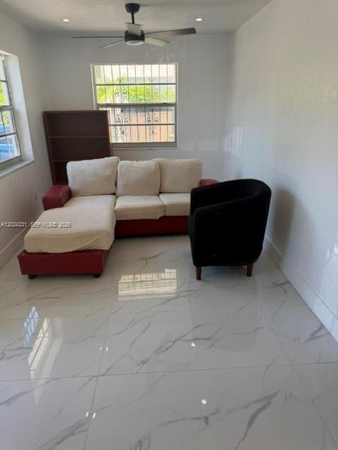 A kitchen features gray cabinets, white countertops, a white stove, and white marble-patterned tile floors — 262 NE 55th Ter # 0, Miami FL 33137, MIAMI, FL