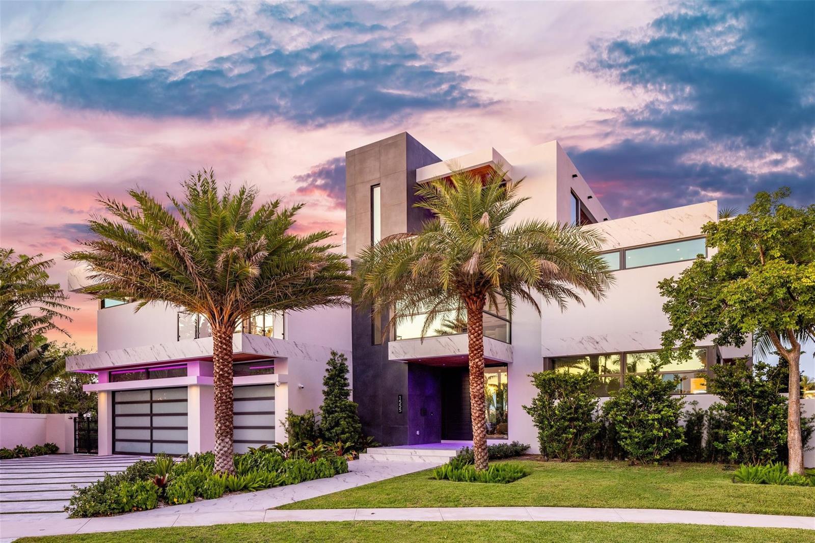 A modern multi-story home with a marble facade, palm trees, and a sunset sky — 1555 SE 14th Court, Deerfield Beach FL 33441, DEERFIELD BEACH, FL