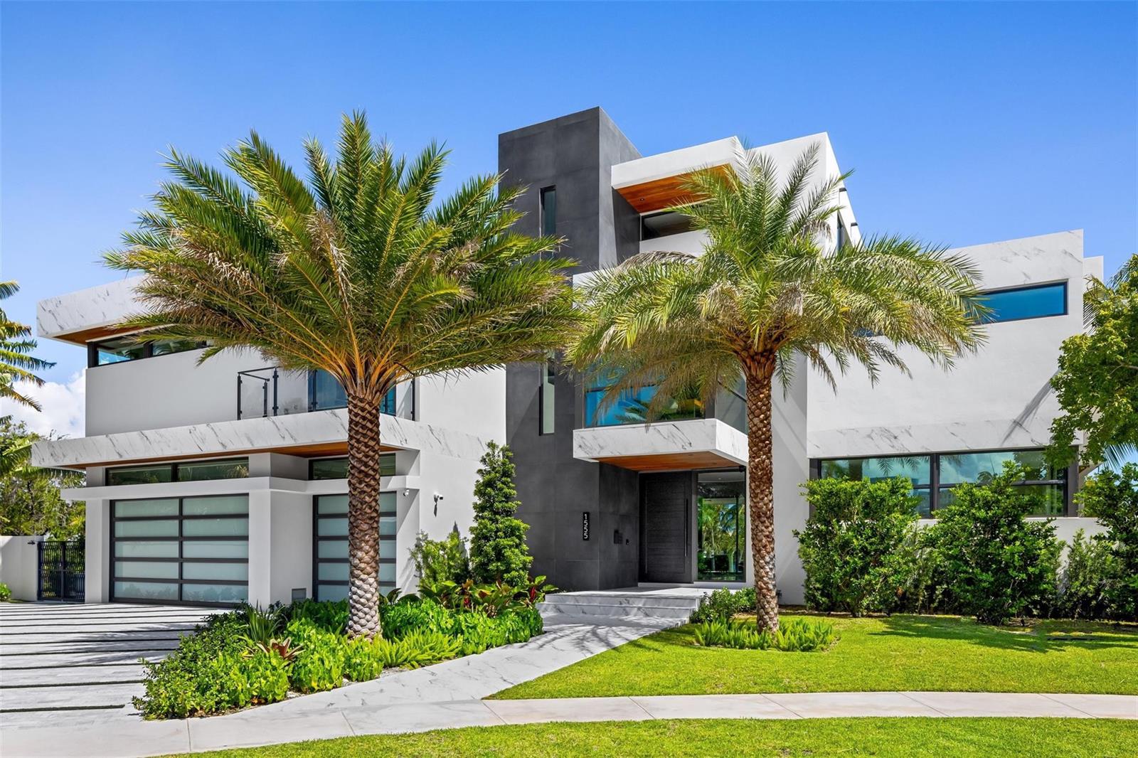 A modern two-story house with white marble-patterned accents, a dark gray central tower, and palm trees — 1555 SE 14th Court, Deerfield Beach FL 33441, DEERFIELD BEACH, FL