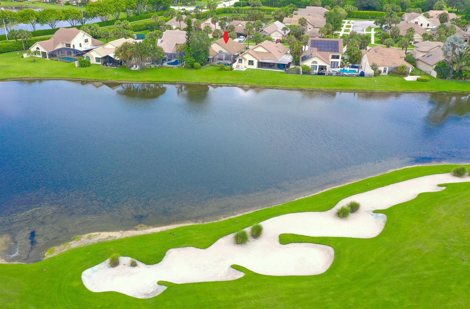 An aerial view of a residential neighborhood bordering a lake and a golf course bunker — 7004 Bitterbush Place, Boynton Beach FL 33472, BOYNTON BEACH, FL