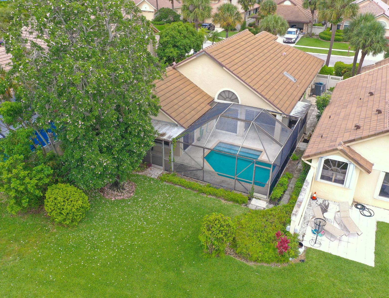An aerial view shows a house with a screened-in pool and a large backyard tree — 7004 Bitterbush Place, Boynton Beach FL 33472, BOYNTON BEACH, FL