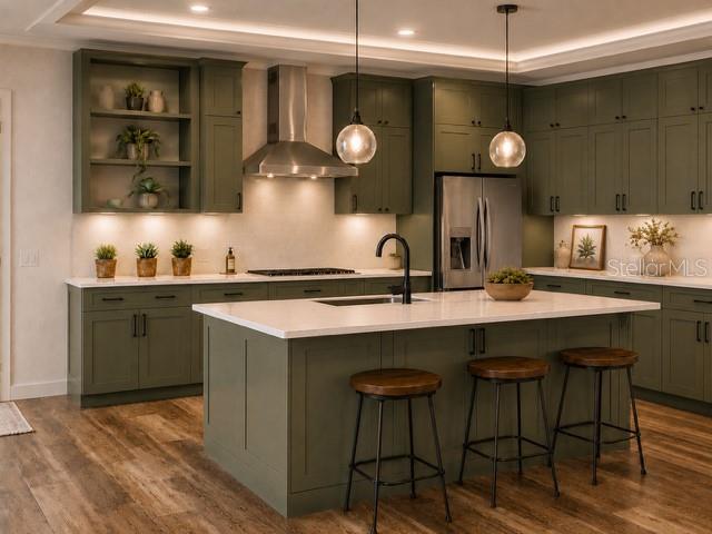 A kitchen features olive green cabinets, a white quartz island, and two pendant lights — 6801 BALSAM PLACE, SEBRING, FL