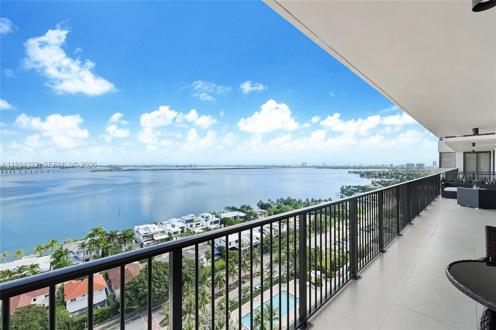 A high-rise balcony overlooks a large body of water, residential homes, and palm trees — 1000 Venetian Way # 1902, Miami FL 33139, MIAMI, FL